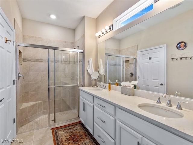 full bathroom with tile patterned flooring, a sink, a shower stall, and double vanity