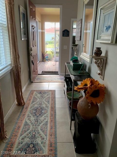 doorway featuring light tile patterned floors and baseboards