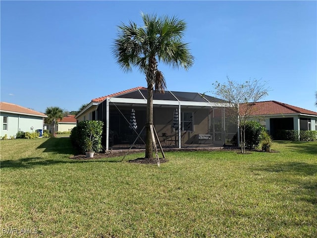 back of house featuring a lanai and a lawn