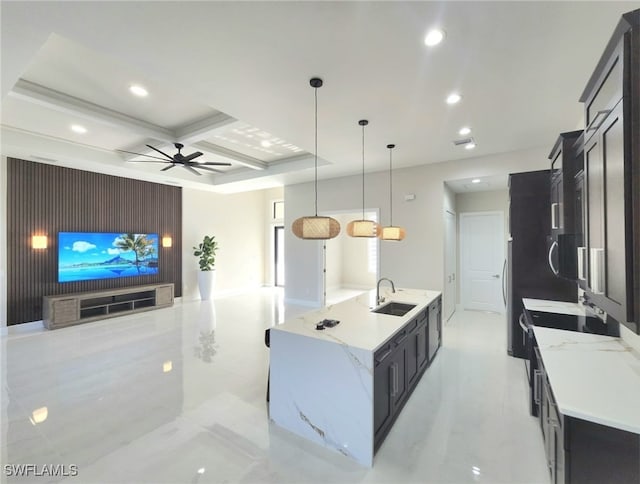 kitchen featuring decorative light fixtures, sink, coffered ceiling, ceiling fan, and a spacious island