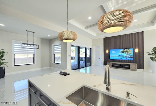 kitchen with coffered ceiling, sink, hanging light fixtures, beamed ceiling, and light stone countertops