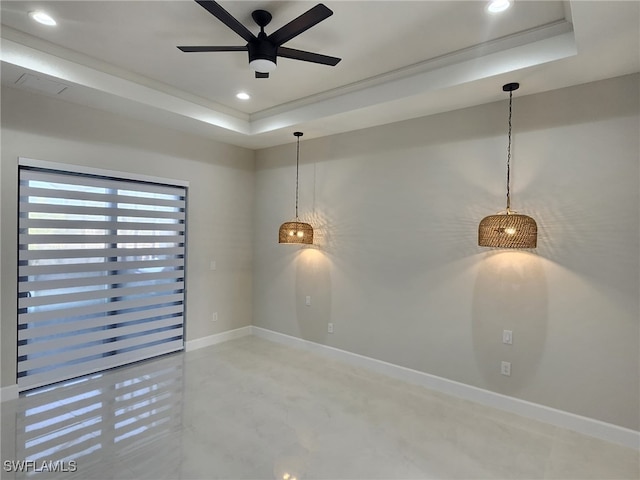 spare room with ceiling fan and a tray ceiling