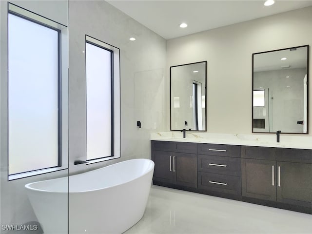 bathroom featuring vanity and a bath