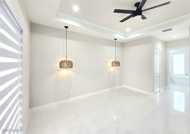 spare room with a raised ceiling and ceiling fan