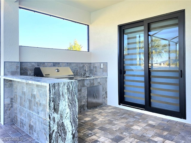 exterior space with an outdoor kitchen, grilling area, and sink