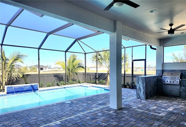 view of pool with ceiling fan, pool water feature, grilling area, and glass enclosure