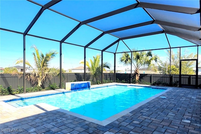 view of pool featuring pool water feature, a patio, and glass enclosure