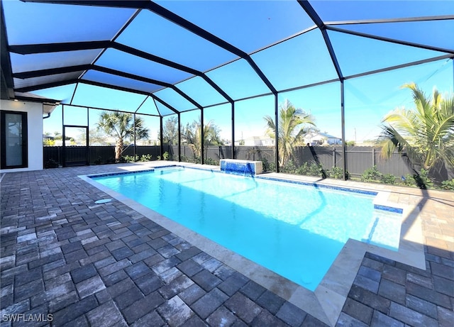 view of swimming pool featuring glass enclosure and a patio area