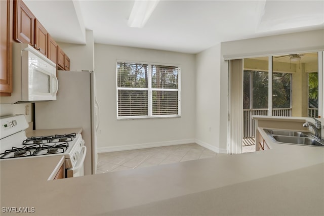 kitchen featuring ceiling fan, white appliances, sink, and light tile patterned floors