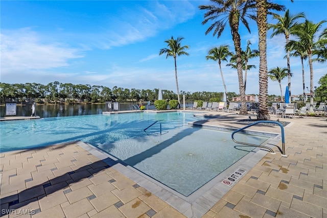 view of pool with a water view and a patio