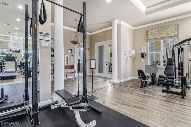 exercise room with crown molding, wood-type flooring, decorative columns, and french doors