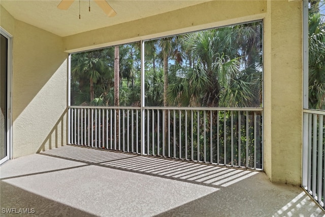 unfurnished sunroom with ceiling fan