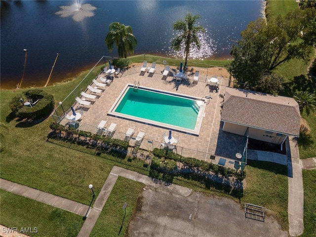 community pool featuring a water view, a patio, and fence