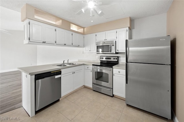 kitchen with stainless steel appliances, a ceiling fan, white cabinetry, a sink, and a textured ceiling