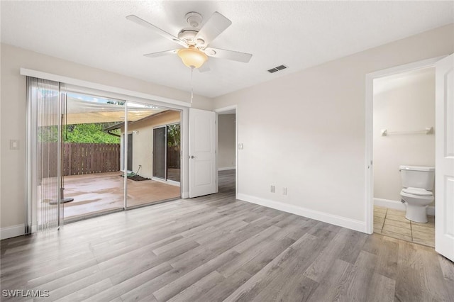 unfurnished bedroom with baseboards, wood finished floors, visible vents, and access to exterior