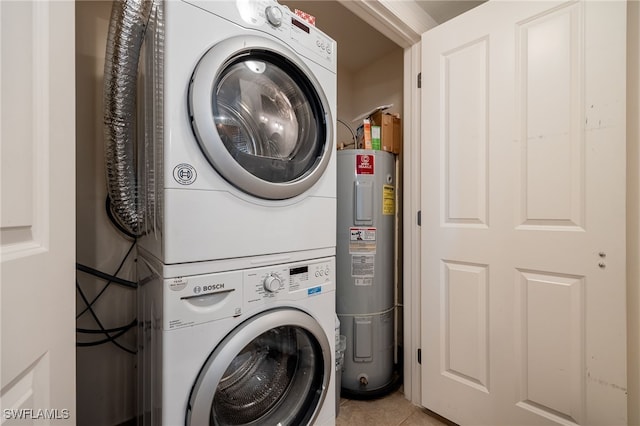 laundry room featuring stacked washer and clothes dryer, electric water heater, and light tile patterned floors