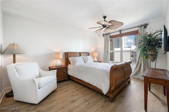 bedroom featuring ceiling fan, ornamental molding, and wood-type flooring