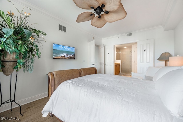 bedroom featuring hardwood / wood-style flooring, ornamental molding, ceiling fan, and ensuite bath