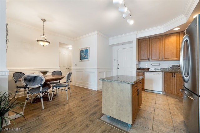 kitchen featuring decorative light fixtures, a center island, dark stone countertops, stainless steel refrigerator, and dishwasher