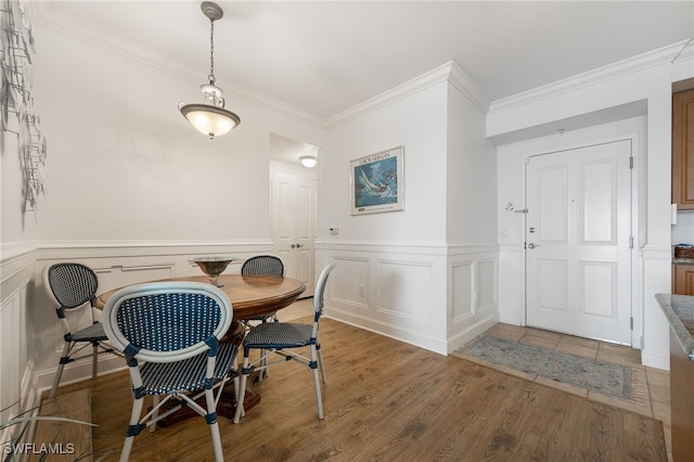 dining room with hardwood / wood-style flooring and crown molding