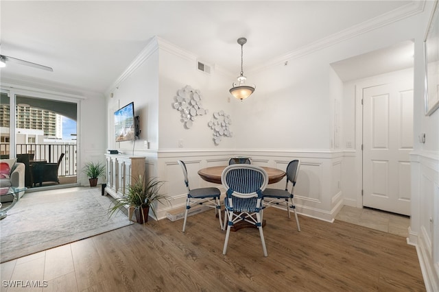 dining area with hardwood / wood-style flooring and ornamental molding