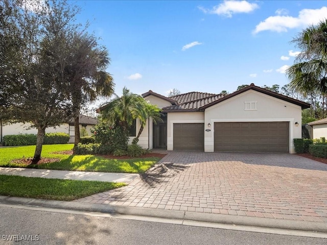 mediterranean / spanish-style home featuring a garage and a front yard