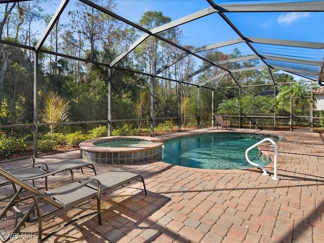 view of swimming pool with a patio area, an in ground hot tub, and glass enclosure