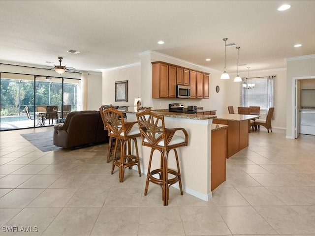 kitchen with pendant lighting, a breakfast bar, stainless steel appliances, light stone counters, and kitchen peninsula