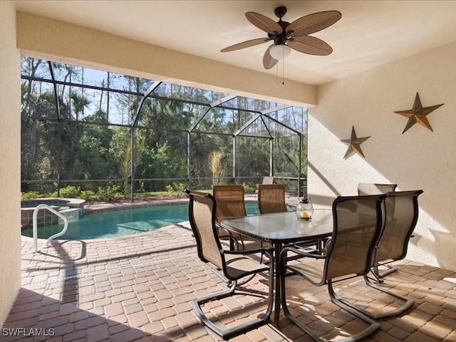 view of pool with ceiling fan, an in ground hot tub, glass enclosure, and a patio area