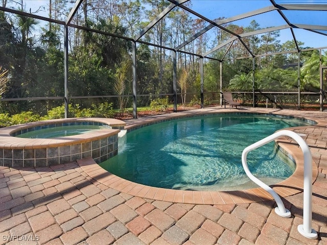 view of swimming pool with an in ground hot tub, glass enclosure, and a patio