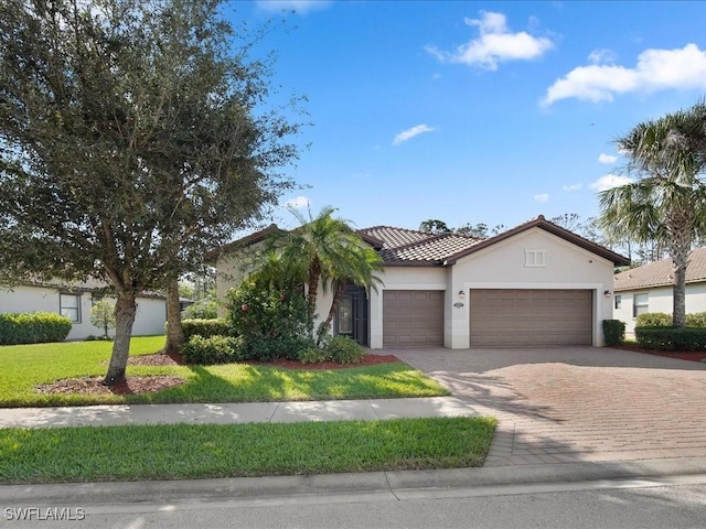 mediterranean / spanish house featuring a garage and a front yard