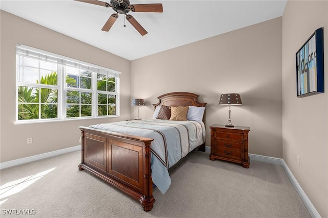 bedroom with light colored carpet, baseboards, and ceiling fan