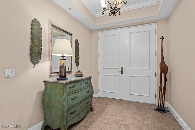 entryway featuring light tile patterned floors, crown molding, a raised ceiling, and a chandelier