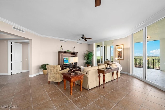 tiled living room with ornamental molding, ceiling fan, and a wall of windows