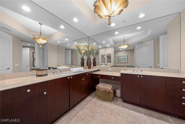 bathroom featuring recessed lighting, a raised ceiling, a notable chandelier, and vanity