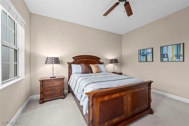 bedroom with multiple windows, light colored carpet, and baseboards