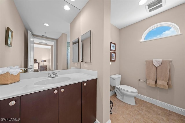 bathroom with vanity, visible vents, baseboards, tile patterned flooring, and toilet