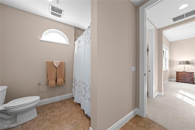 bathroom featuring tile patterned floors, toilet, baseboards, and visible vents