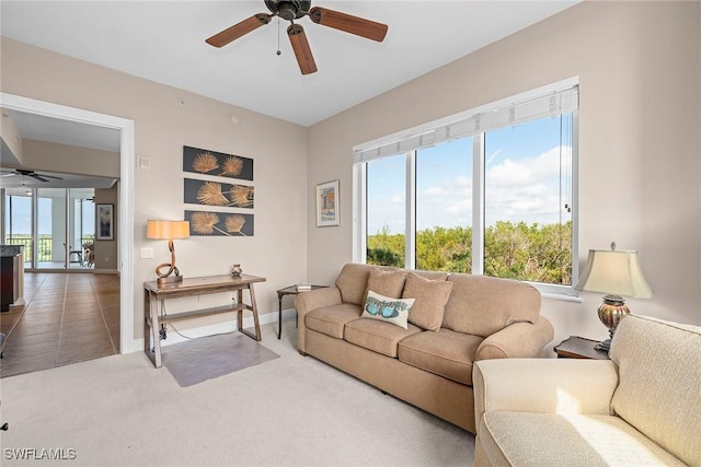 living room featuring carpet flooring, a ceiling fan, and a wealth of natural light