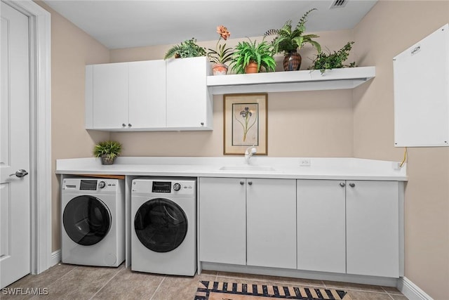 washroom with baseboards, visible vents, cabinet space, a sink, and independent washer and dryer