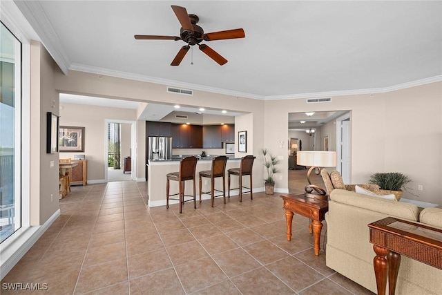 living room featuring visible vents, a ceiling fan, and crown molding