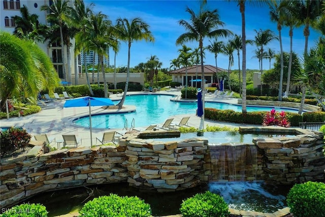 view of swimming pool featuring pool water feature and a patio