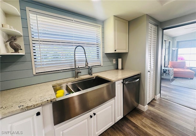 kitchen featuring light stone counters, sink, dark hardwood / wood-style flooring, and stainless steel dishwasher