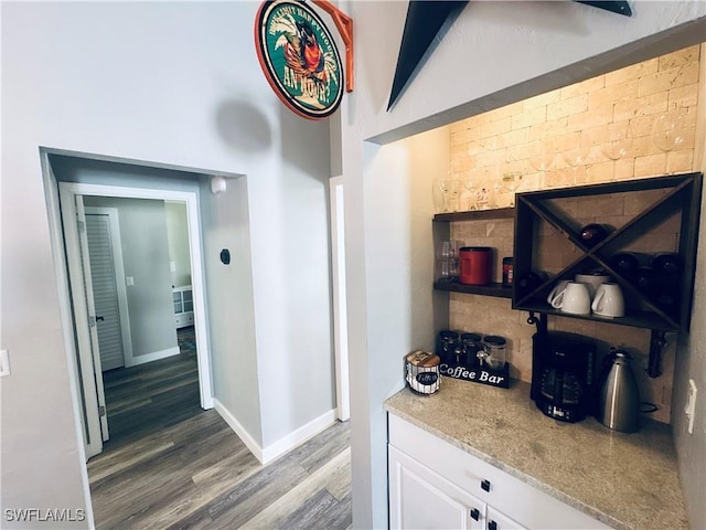 interior space featuring white cabinetry, light stone counters, and dark hardwood / wood-style floors