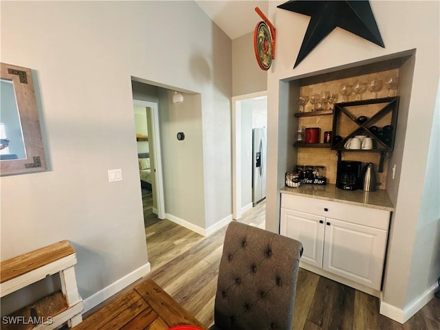 hallway featuring lofted ceiling and dark hardwood / wood-style flooring