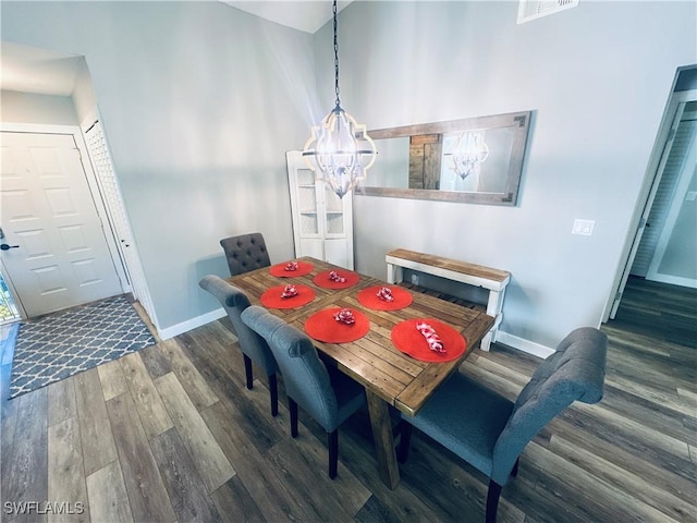 dining area with dark wood-type flooring and a chandelier