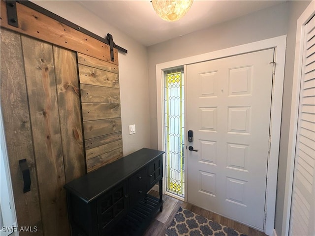 foyer entrance featuring a barn door and dark hardwood / wood-style flooring