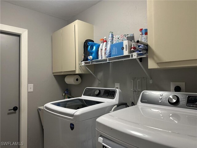 washroom featuring washing machine and dryer and cabinets