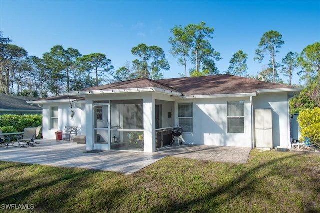 back of property featuring a sunroom, a yard, and a patio