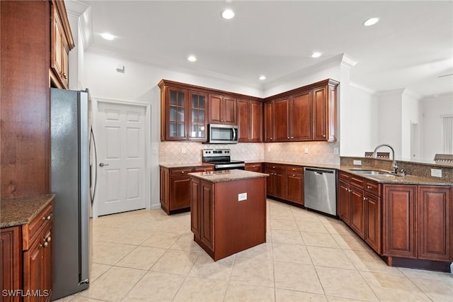 kitchen with sink, stainless steel appliances, a center island, kitchen peninsula, and dark stone counters